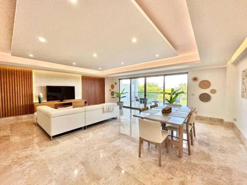 a living room with a white couch and a table at Depto. playa y confort amenidades frente al mar in Cancún