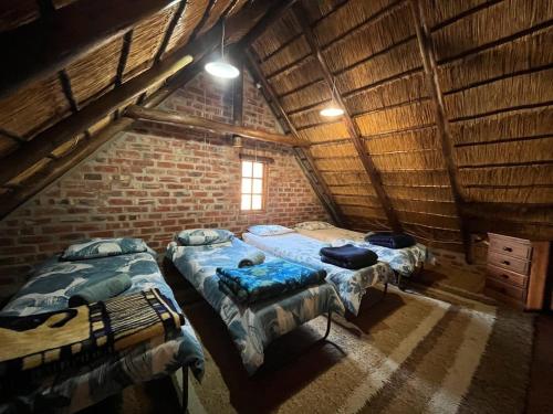 two beds in a room with a brick wall at Schoemanshof in Potchefstroom