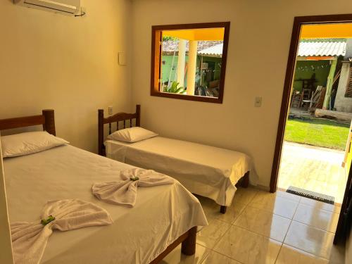 2 łóżka w pokoju z lustrem i oknem w obiekcie POUSADA SOL DE VERÃO - Cumuruxatiba -BA w mieście Prado