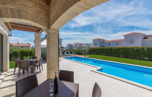 a patio with a table and chairs next to a swimming pool at Villa Lory in Vabriga