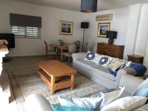 a living room with a couch and a table at Santos Villa in Quinta do Lago in Quinta do Lago
