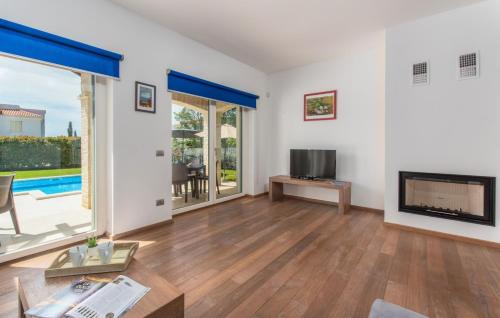 a living room with a fireplace and a tv at Villa Lory in Vabriga