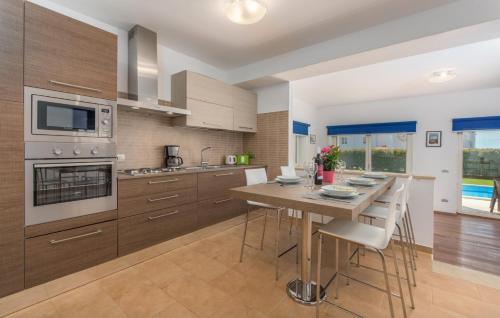 a kitchen with wooden cabinets and a wooden table with chairs at Villa Lory in Vabriga