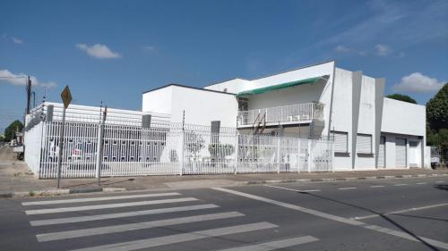 een wit gebouw met een hek naast een straat bij Loft lindo, acochegante e reservado in Boa Vista