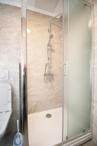 a shower with a glass door in a bathroom at Apartmani Sebastijan in Banja Luka