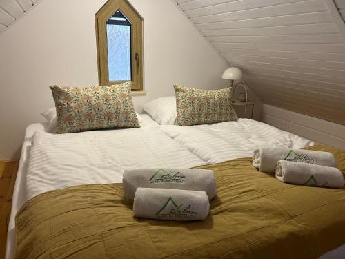a large bed with two pillows on top of it at Activfarm domki na Kaszubach /domek Madzia in Lipnica
