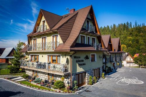 una casa grande con techo de gambrel en Willa Górska Dolina Jacuzzi & Sauna, en Poronin