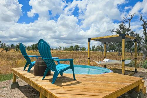 dos sillas sentadas en una mesa junto a una piscina en Doss-Spring Creek Cabin, en Tivydale