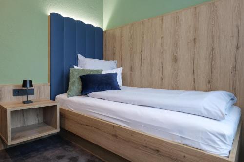a bedroom with a large bed with a wooden headboard at Reos Hotel Isny in Isny im Allgäu