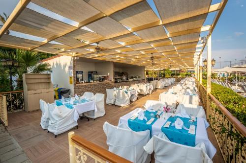 a restaurant with white tables and white chairs at Aydinbey Gold Dreams - Ultra All Inclusive in Avsallar