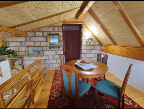 una sala da pranzo con tavolo e sedie in legno di Planinska kuća Jahorinka a Pale
