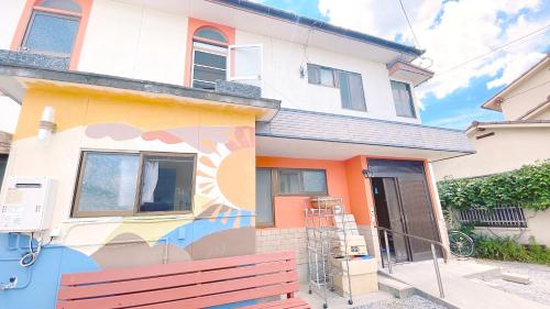 a house with a painting on the side of it at AKARIYA Home&Hostel in Karatsu