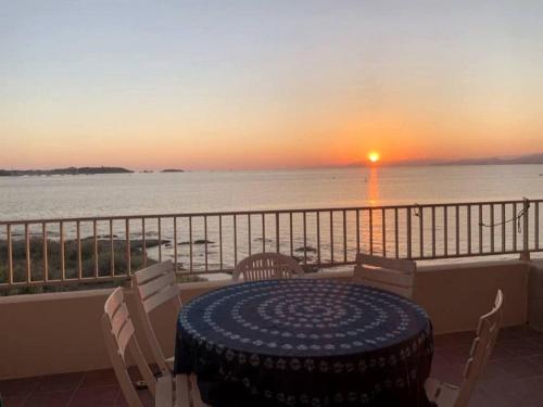 d'une table et de chaises sur un balcon avec vue sur le coucher du soleil. dans l'établissement Sublime Bord de mer, proche Sanary & Bandol, à Six-Fours-les-Plages
