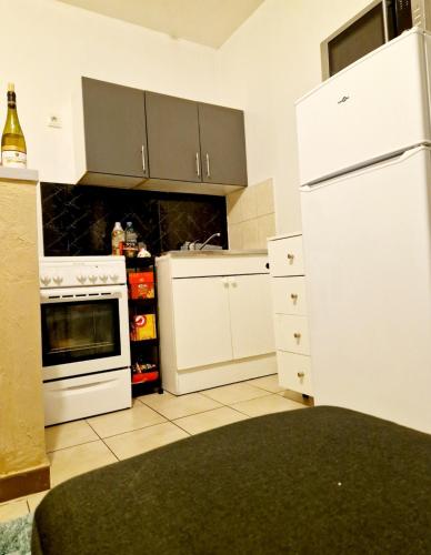 eine Küche mit weißen Schränken und einem weißen Kühlschrank in der Unterkunft Charmant T2 Argenteuil in Argenteuil