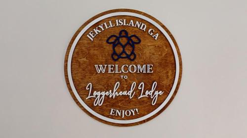 a wooden medal with a welcome to luquilla island cafe at LOGGERHEAD LODGE home in Jekyll Island