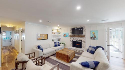 a living room with two couches and a fireplace at LOGGERHEAD LODGE home in Jekyll Island