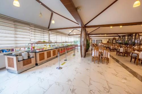 a restaurant with a buffet line with tables and chairs at Aydinbey Gold Dreams - Ultra All Inclusive in Avsallar