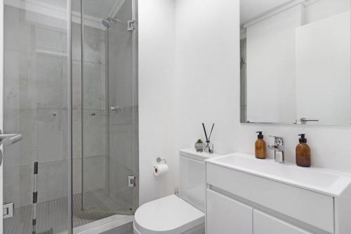 a bathroom with a shower and a toilet and a sink at Stunning Modern apartment Cape Town City Centre. in Cape Town