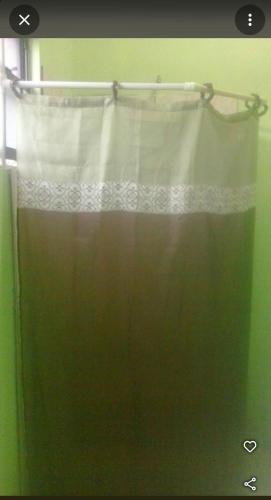 cortina de ducha en un baño con ventana en The Hillside Hideaway, en Micoud