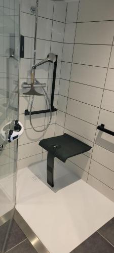 a black bench in a room with a shower at Charmant appartement 3* au cœur des Vosges (PMR) in Vecoux