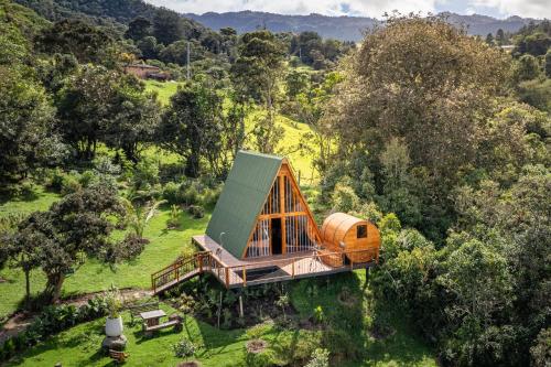 an overhead view of a wooden house in a field at La Gloria Reserva Forestal in La Calera