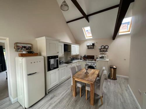 a kitchen with a table and a white refrigerator at Barn conversion with hot tub in Lincoln