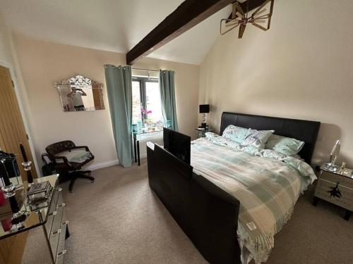 a bedroom with a large bed and a window at Barn conversion with hot tub in Lincoln