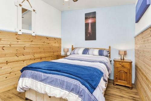 Un dormitorio con una cama y una pared de madera. en The Sea Shack, en Ventnor