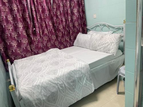 Cama pequeña en habitación con cortina en Relaince lucky home, en Hong Kong