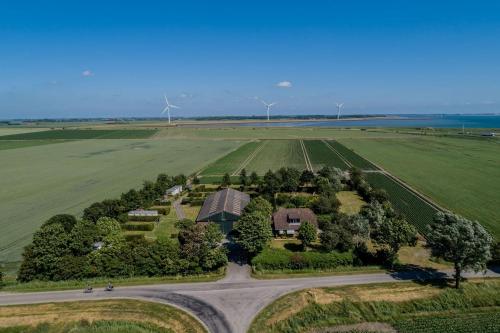 an aerial view of a house in a field with wind turbines at Camping 'de Val' in Zierikzee