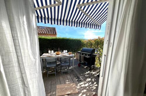 a patio with a table and chairs and a grill at Domaine des Vignes Golfe de Saint Tropez in Cogolin