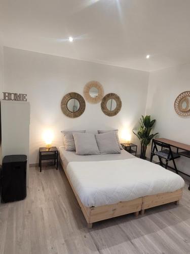 a bedroom with a bed and two mirrors on the wall at Le Provençal in Saint-Mitre-les-Remparts