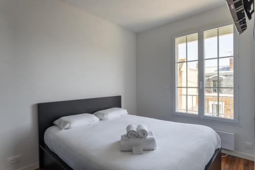 une chambre avec un lit avec deux serviettes dessus dans l'établissement Le Dinghy - Appartement pour 4, à Saint-Malo