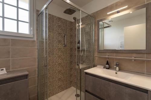 une salle de bain avec une douche, un lavabo et un miroir dans l'établissement Le Dinghy - Appartement pour 4, à Saint-Malo