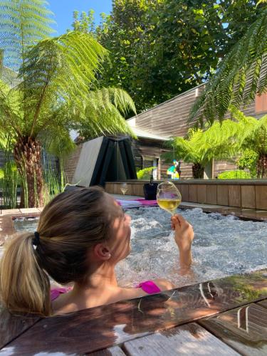 a girl in a pool with a glass of wine at La villa 10 HÔTEL SPA in Étretat