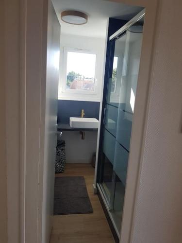 une salle de bain avec un lavabo et une fenêtre dans l'établissement Appartement cosy et rénové, au Pouliguen