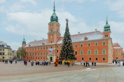 Un árbol de Navidad delante de un gran edificio en One Bedroom Apartment Next to the Royal Castle in Warsaw by Renters, en Varsovia
