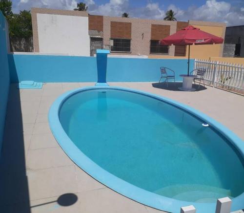 Una gran piscina azul en un edificio. en Linda casa em pequeno condominio! Disponível curtas medias e longas temporadas, en Aracaju