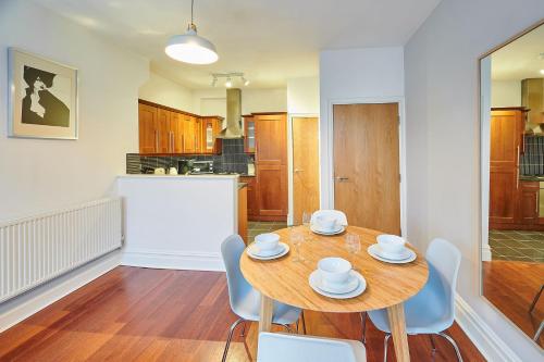 uma cozinha e sala de jantar com uma mesa de madeira e cadeiras em Host & Stay - The Ivanhoe Retreat em Liverpool