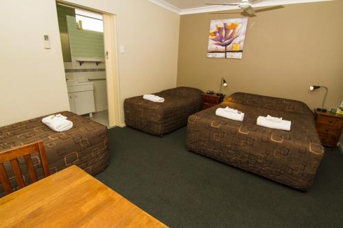 a living room with two couches and a table at Green Gables Motel in Dubbo