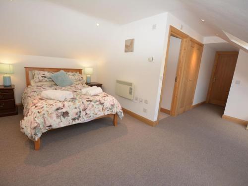 1 Schlafzimmer mit einem Bett mit Blumenbettdecke in der Unterkunft 2 Bed in Fairbourne 43105 in Arthog