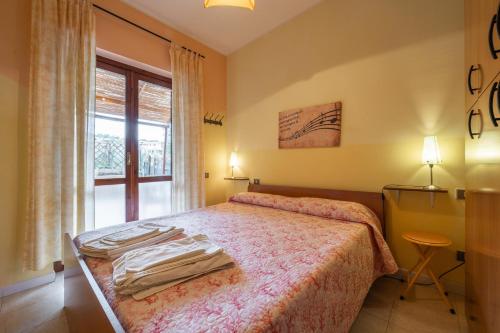 维拉西米乌斯Pentagramma Apartment Villasimius的一间卧室，里面有一张床和一扇窗户。