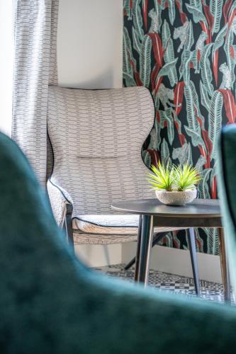 a chair and a table with two plants on it at La villa 10 HÔTEL SPA in Étretat