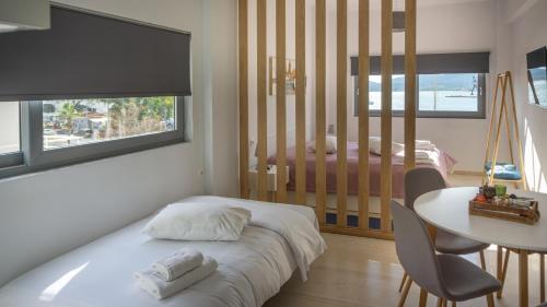 1 dormitorio con cama, mesa, mesa y silla en Nest Port View Apartment en Volos