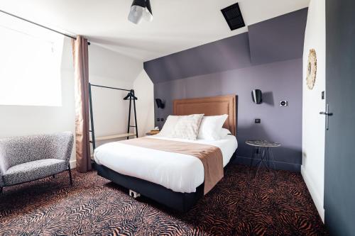 a hotel room with a bed and a chair at La villa 10 HÔTEL SPA in Étretat