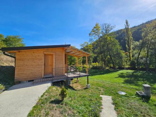 uma pequena cabana com um alpendre num campo de relva em Apartment Ostojic em Mokra Gora