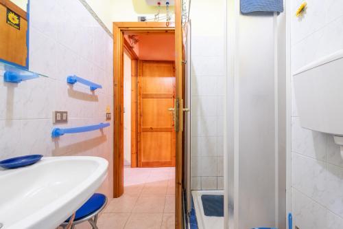 维拉西米乌斯Pentagramma Apartment Villasimius的一间带水槽和木门的浴室