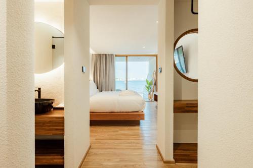 a bedroom with a bed and a view of the ocean at Tasana bar and luxury resort in Ko Larn