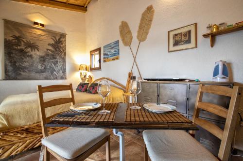 a dining room table with two chairs and a table with wine glasses at Stazzo Jana in Trinità dʼAgultu
