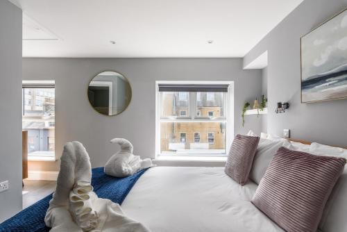 een woonkamer met een witte bank en een spiegel bij Cosy 2-Bedroom Double En-Suite - Cathedral Views in Norwich